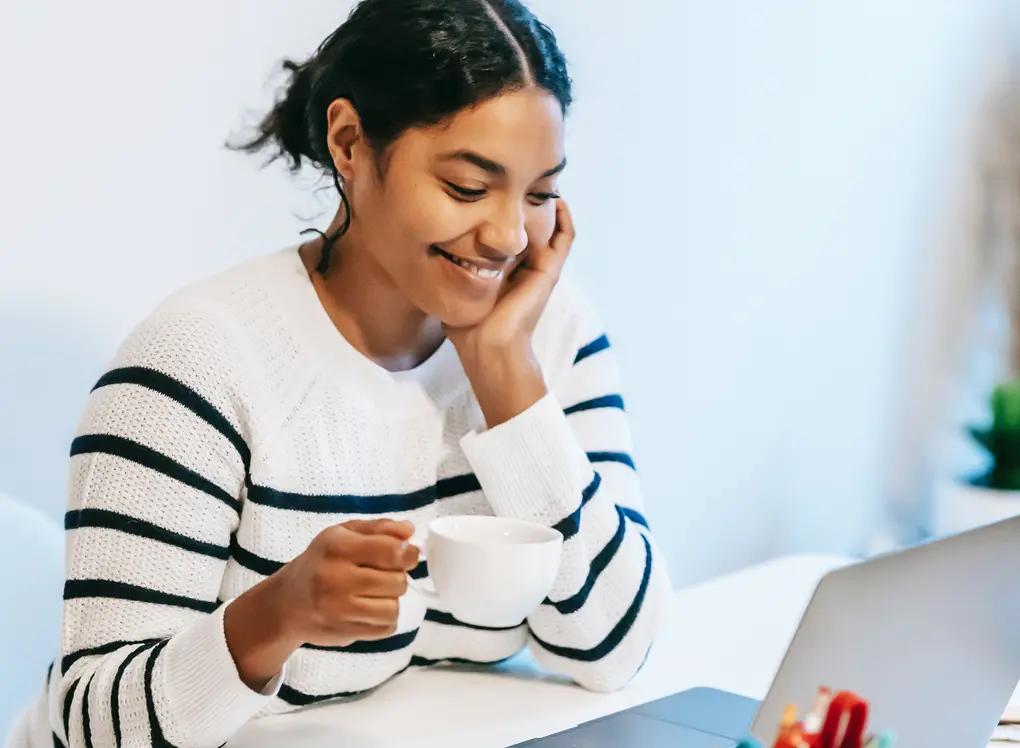 Photo of a woman smiling behind a desk, representing a positive experience